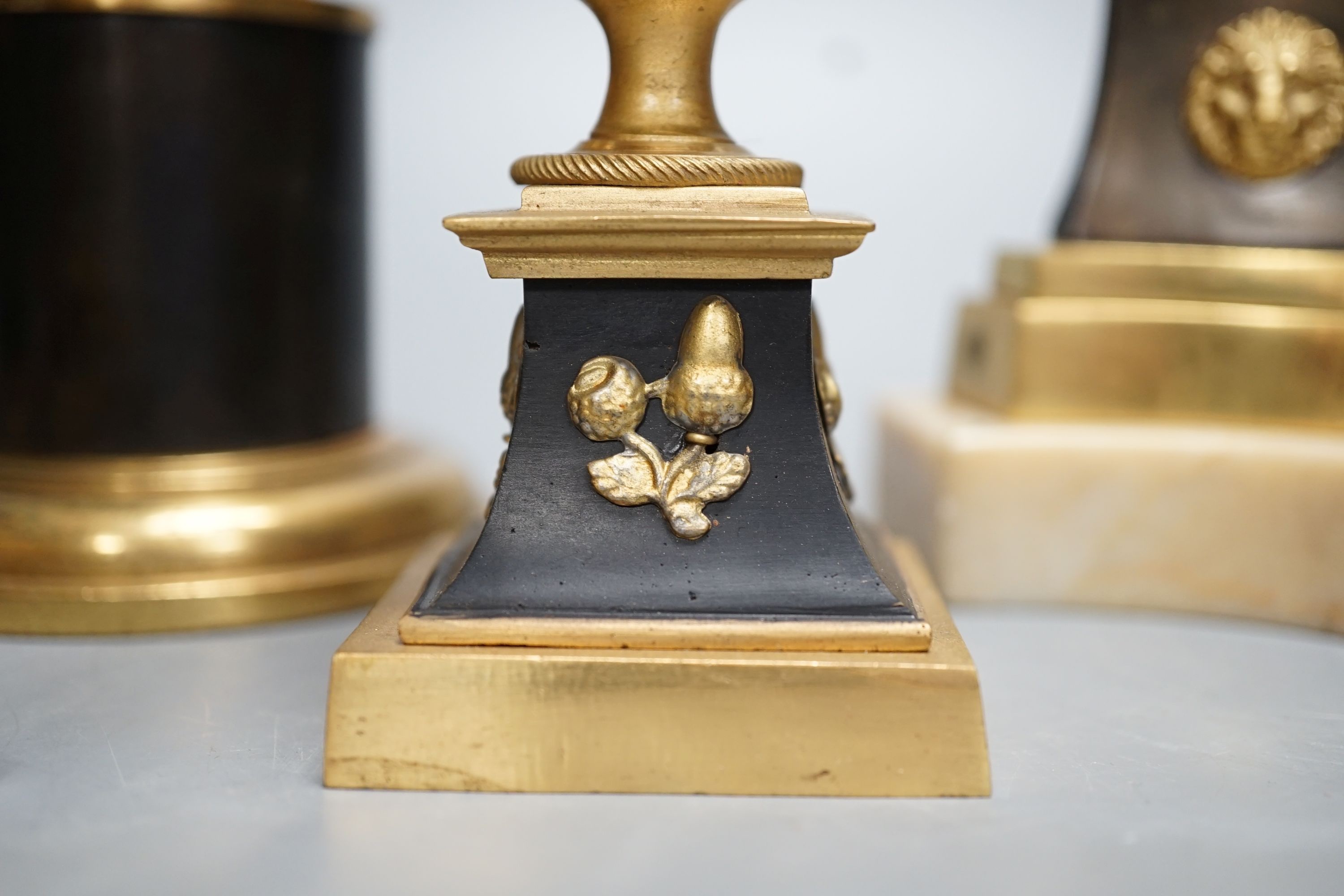 A pair of Louis XVI style ormolu and bronze models of campana urns and two similar pairs of Empire style candlesticks